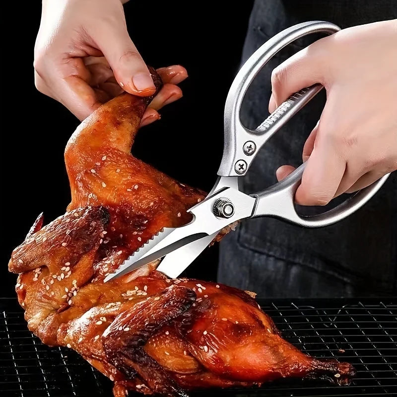Ciseaux de cuisine multifonctionnels en acier inoxydable 304 coupant un poulet rôti sur une grille.